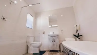 a bathroom with a tub and a toilet and a sink at Cosy Nest - Uncapped Wi-fi & Self Check-in in Cape Town
