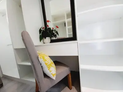 a chair with a pillow sitting under a mirror at Cosy Nest - Uncapped Wi-fi & Self Check-in in Cape Town