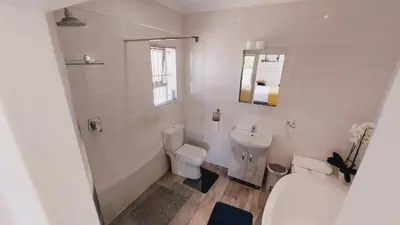 a white bathroom with a toilet and a sink at Cosy Nest - Uncapped Wi-fi & Self Check-in in Cape Town