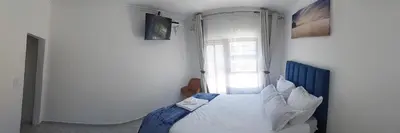a bedroom with a white bed in front of a window at Blue Nile Guest in Cape Town