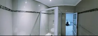 a bathroom with a shower with a glass door at Blue Nile Guest in Cape Town