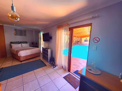a bedroom with a bed and a swimming pool at Durbanville Pool House in Durbanville