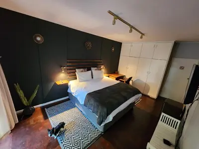 a bedroom with a large bed in a room at Durbanville Pool House in Durbanville