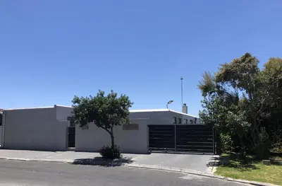 a white building with a gate in front of a street at Nature's Rest in Cape Town