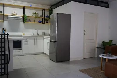 a kitchen with a stainless steel refrigerator in a room at Nature's Rest in Cape Town