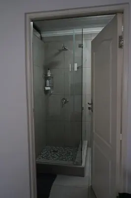 a bathroom with a shower with a glass door at Nature's Rest in Cape Town