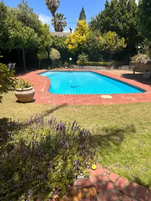 a large swimming pool in a yard with a yard at Garden View Inn in Cape Town