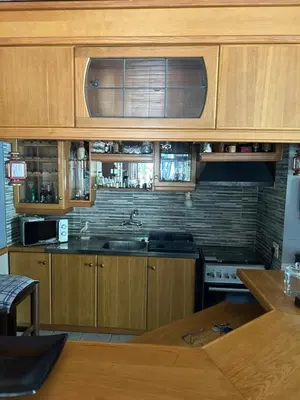 a kitchen with wooden cabinets and a sink and a stove at Garden View Inn in Cape Town