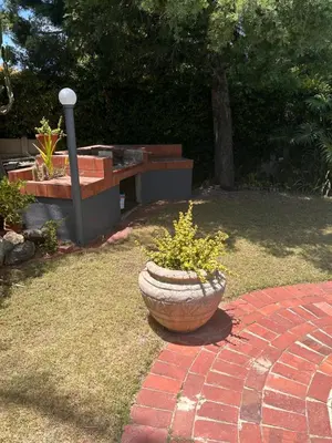 a stone pot with a plant in a yard at Garden View Inn in Cape Town