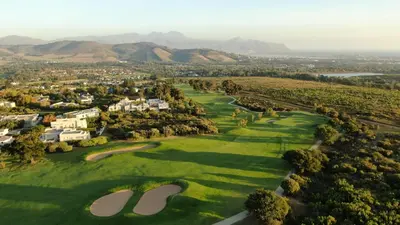 an aerial view of a golf course with mountains in the background at Erinvale Luxury Villa in Cape Town