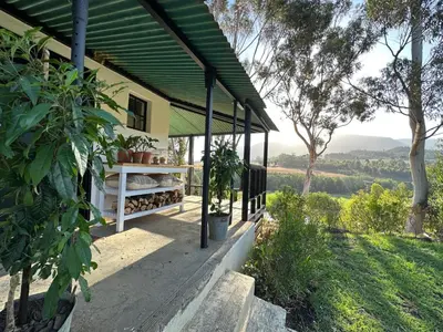 a porch of a house with a view of a field at Cornellskop Country Stay in Botrivier