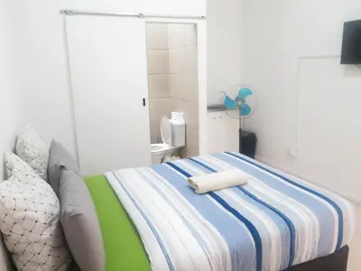 a bedroom with a bed with two towels on it at lodgeon91 in Cape Town