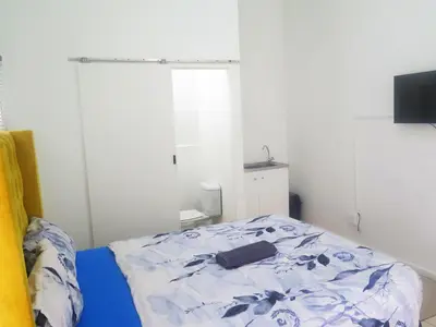 a bedroom with a bed with a blue and white comforter at lodgeon91 in Cape Town