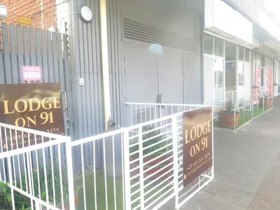 a couple of signs on a fence in front of a store at lodgeon91 in Cape Town