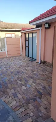 an empty driveway in front of a house with a garage at Cozy Batchelor Labiance in Cape Town