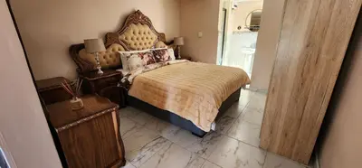 a bedroom with a large bed with a wooden headboard at Cozy Batchelor Labiance in Cape Town
