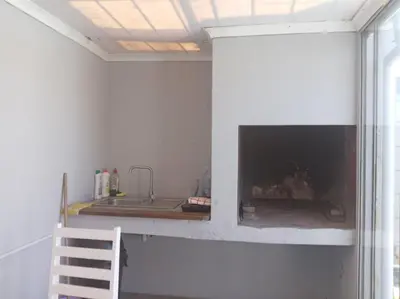 a kitchen with a fireplace in a white wall at Naliya Guest house in Cape Town