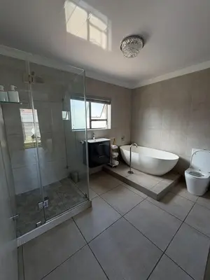 a bathroom with a tub and a shower and a toilet at Naliya Guest house in Cape Town