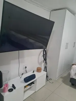a large flat screen tv on a white wall at Elikem Properties in Cape Town