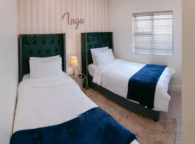 a bedroom with two beds and a window and acknowled at Lovely and Peaceful 3 bedroom house in Cape Town