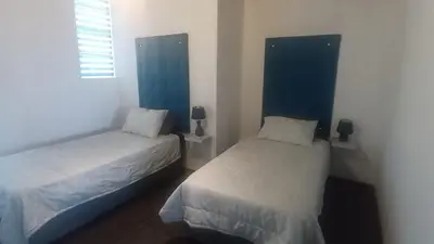 a bedroom with two beds and a window at Whalers Retreat in Bettyʼs Bay