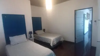 a small bedroom with two beds and a mirror at Whalers Retreat in Bettyʼs Bay