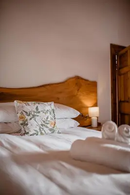 a bedroom with a white bed with a wooden headboard at Heins Manor House in Stellenbosch