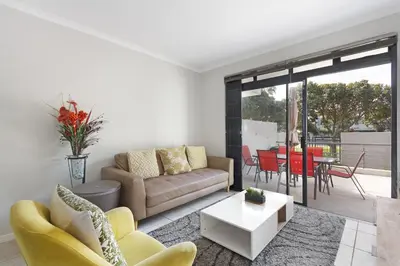 a living room with a couch and a table at Waterstone East C103 by Host Agents in Cape Town