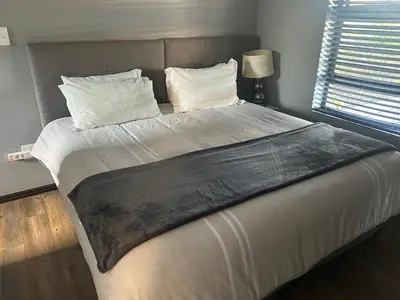 a large bed with white sheets and pillows in a bedroom at 81 on Groenewoud in Cape Town