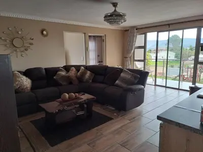 a living room with a black couch and a table at Elim Rest Place in Fisherhaven