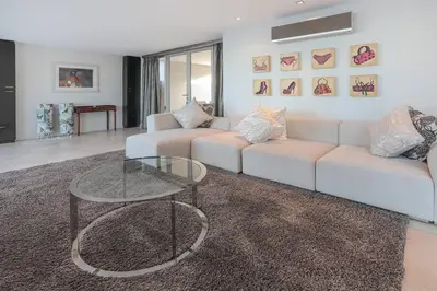 a living room with a couch and a glass table at Benguela Cove - Oceans Away in Hermanus
