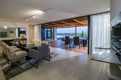 a kitchen and dining room with a table and chairs at Benguela Cove - Utopia in Hermanus