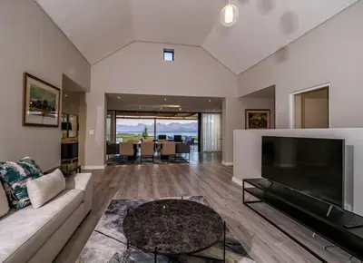 a living room with a large television and a couch at Benguela Cove - Utopia in Hermanus