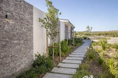 a stone path next to a brick building at Benguela Cove - Coastal Retreat in Hermanus