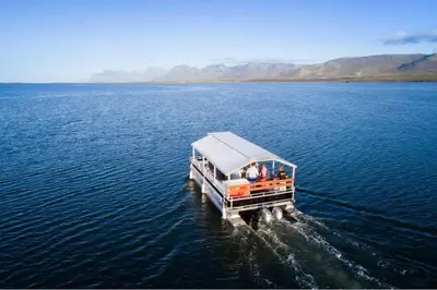 a boat in the middle of a large body of water at Benguela Cove - Coastal Retreat in Hermanus