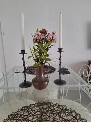 a glass table with two candles and a vase with flowers at Eucalyptus Cottage in Cape Town