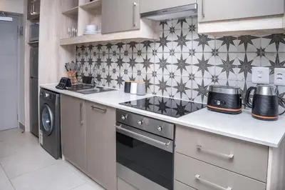 a kitchen with a stove top oven next to a dishwasher at Stylish Studio Stellenbosch - Airconditioned in Stellenbosch