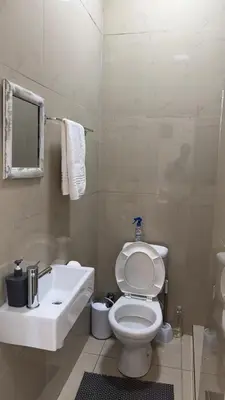 a bathroom with a white toilet and a sink at MELJAA STAR Guesthouse in Cape Town