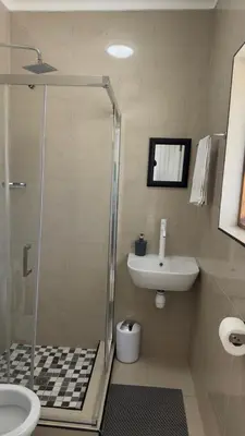 a bathroom with a shower and a sink at MELJAA STAR Guesthouse in Cape Town