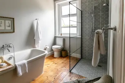 a bathroom with a tub and a shower and a toilet at The Belmont in Franschhoek