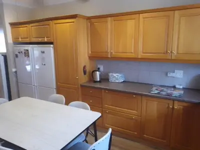 a kitchen with wooden cabinets and a white refrigerator at Somstuis in Hermanus