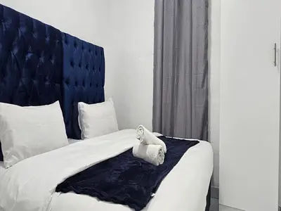 a bedroom with a bed with a towel on it at Goshen Lodge Fitzroy in Cape Town