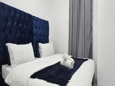 a black and white photo of a bed with a towel on it at Goshen Lodge Fitzroy in Cape Town