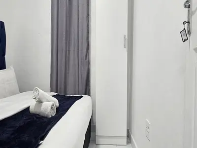 a hotel room with a bed with a towel on it at Goshen Lodge Fitzroy in Cape Town