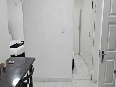 a white room with a white door and a table at Goshen Lodge Fitzroy in Cape Town