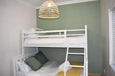 a bedroom with bunk beds and a pendant light at The Botanical House in Somerset West