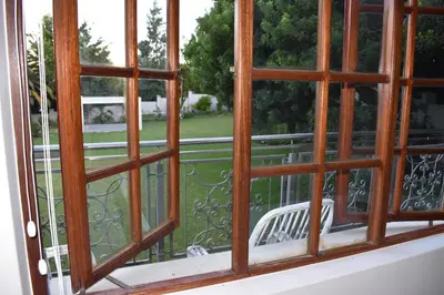 an open window with a view of a yard at The Botanical House in Somerset West
