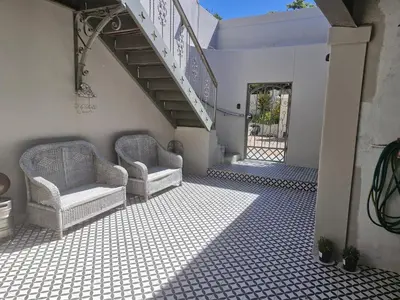 a room with two chairs and a staircase at The Botanical House in Somerset West