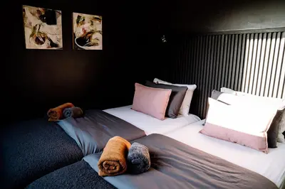 two twin beds in a room with black walls at Klein-Hangklip in Rooiels
