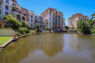 a pond in the middle of a city with buildings at 405 Portofino Eyrie Holiday Apartments in Cape Town